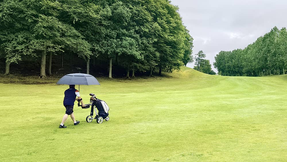 golfer on course with umbrella